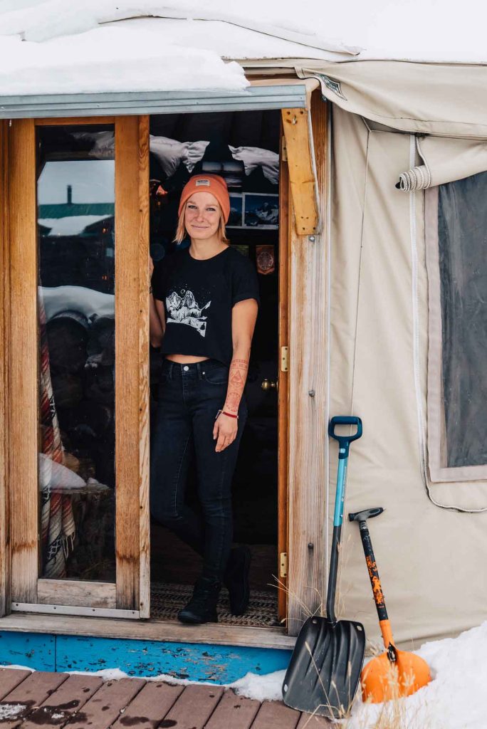 Marinna Elinski standing in the doorway of her yurt.